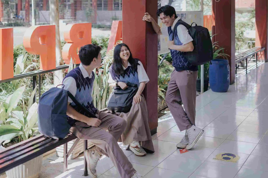 beberapa orang yang mengenakan seragam sedang bercanda gurau di koridor sekolah