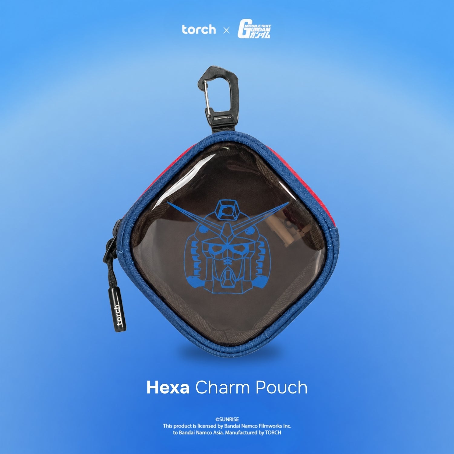 A hexagonal clear pouch with a blue zipper and black carabiner clip, featuring a blue Gundam logo on the front. The pouch is displayed against a blue gradient background with 'torch x G-1000' at the top and 'Hexa Charm Pouch' at the bottom.