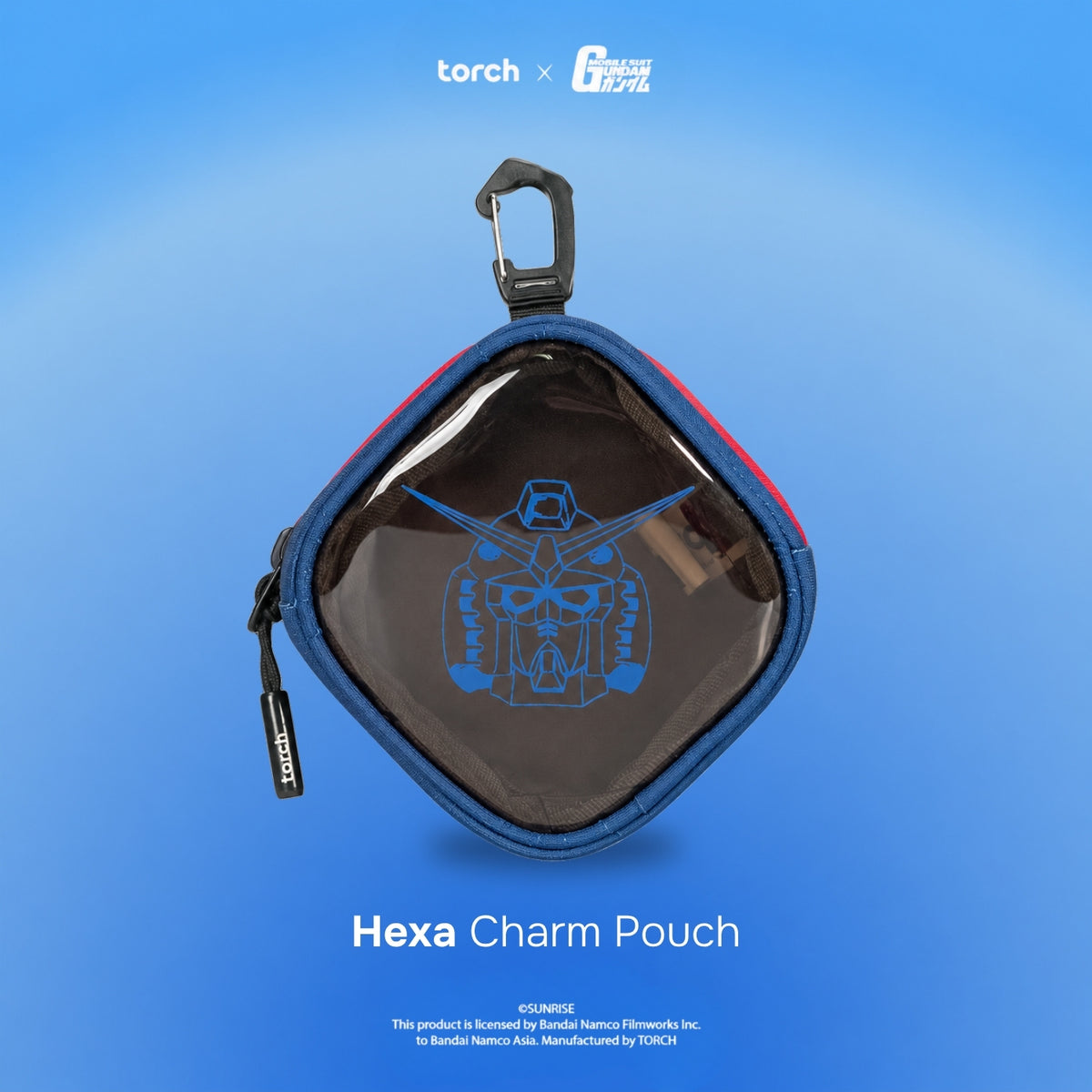 A hexagonal clear pouch with a blue zipper and black carabiner clip, featuring a blue Gundam logo on the front. The pouch is displayed against a blue gradient background with 'torch x G-1000' at the top and 'Hexa Charm Pouch' at the bottom.