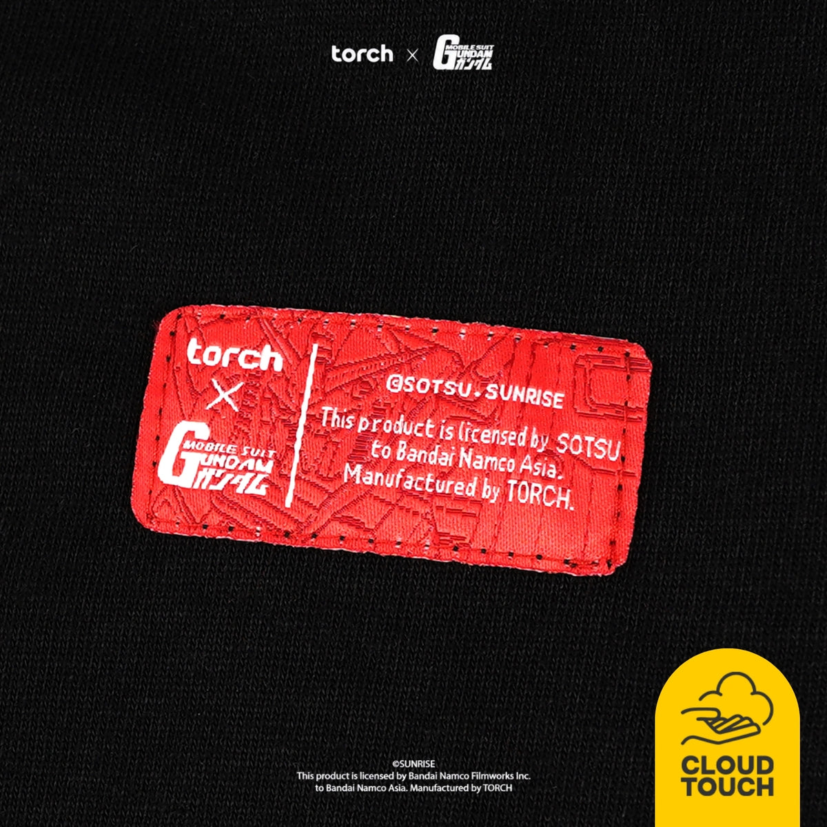 Close-up of a black garment with a rectangular red patch showing white text and branding, including 'torch' and 'SOTSU x SUNRISE' plus licensing text. A yellow 'CLOUD TOUCH' logo appears in the bottom-right corner.