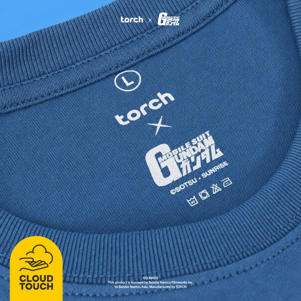Close-up of the inside collar of a blue T-shirt showing printed white branding and graphics, including the words 'torch' and 'GUNDAM'. A yellow 'CLOUD TOUCH' logo appears in the bottom-left corner.