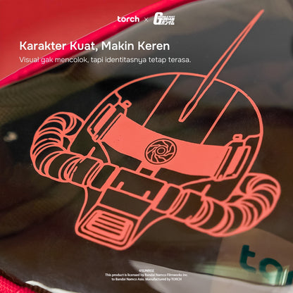 A close-up of a glossy black surface featuring a large red line-art illustration of a zaku. White promotional text appears at the top left, including 'Karakter Kuat, Makin Keren' and small logos at the top center.