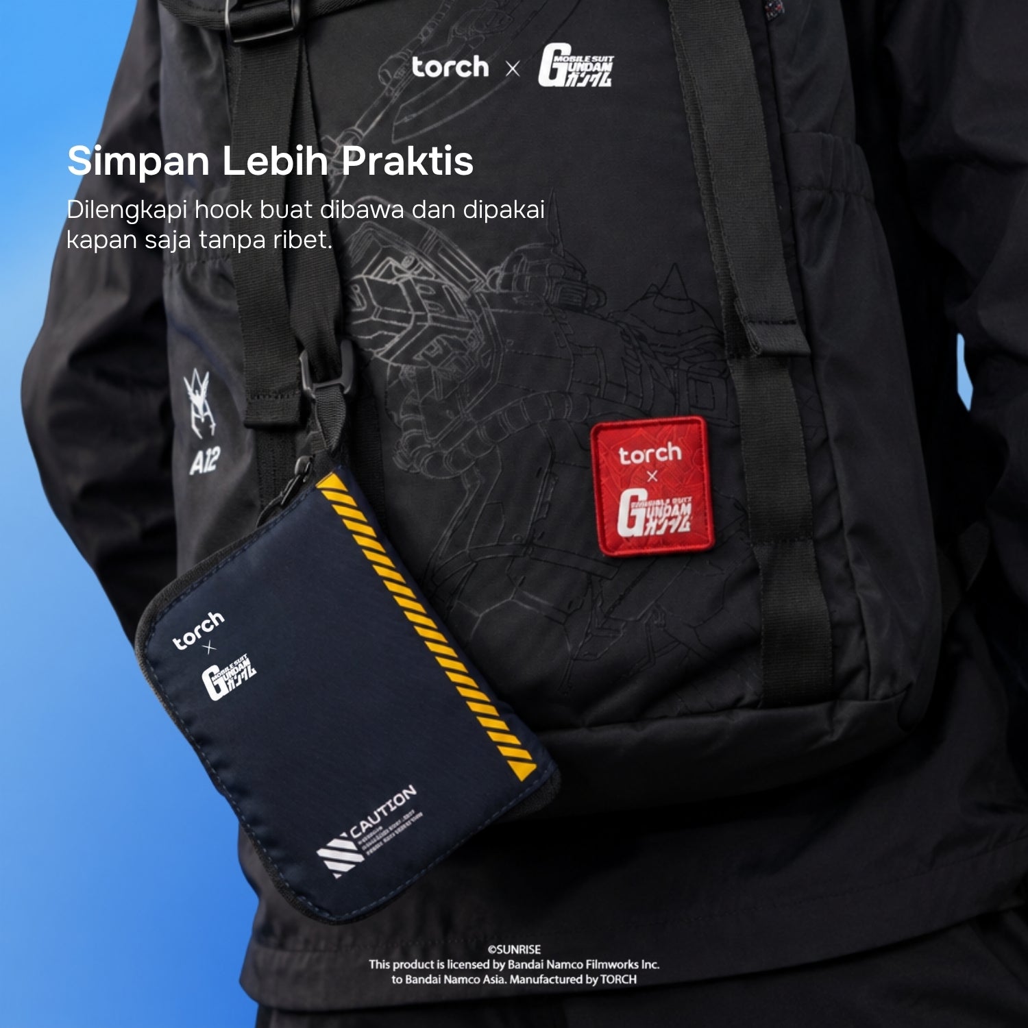 A black Torch x G-1000 crossbody bag worn over a black jacket, with a matching black pouch hanging at the side. The pouch has a red square Torch x G-1000 patch and white branding, and the main bag has subtle tonal graphics and a red patch.
