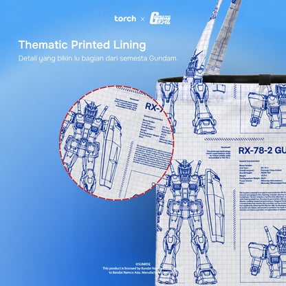 A tote bag with a blue and white Gundam-themed blueprint print, shown alongside a circular inset highlighting the printed lining detail. The image features 'torch' and 'Gundam Model' branding on a blue gradient background.